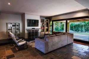 Una gran sala de estar con un sofá y un televisor. en Home in Cape Town-The Homestead, en Stellenbosch