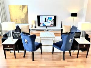 ein Wohnzimmer mit blauen Stühlen und einem Sofa in der Unterkunft MONDRIAN Luxury Suites & Apartments Market Square I in Warschau