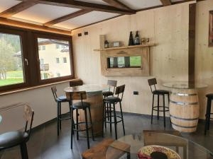 a bar with stools and tables in a room at Soggiorno Dolomiti in Mazzin