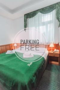 - une chambre avec un lit vert et un parking gratuit dans l'établissement Hotel Peko, à Prague