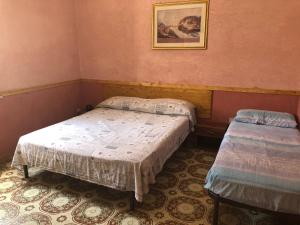 two beds in a room with pink walls at Casa Vacanze "Isole e Tramonti" in Marsala