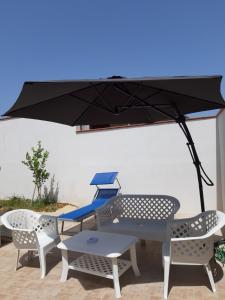 a table and chairs under an umbrella on a patio at Casa vacanza Viola in Trapani