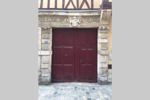 una gran puerta roja en un edificio con un ladrillo en Charmant studio hypercentre en Rouen