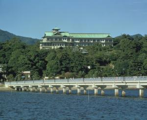 un puente sobre el agua con un edificio al fondo en Gamagori Classic Hotel en Gamagori