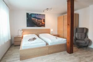 una camera da letto con un letto e una sedia di Vila Šumná a Luhačovice