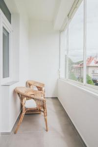 Vila Šumná في لوهاتشوفيتسا: كرسي الخوص جالس في غرفة مع نافذة