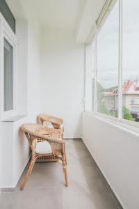 una sedia in vimini seduta in una stanza con finestra di Vila Šumná a Luhačovice