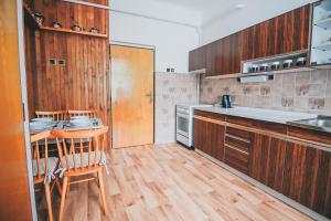 una cucina con armadi in legno, tavolo e sedie di Vila Šumná a Luhačovice Altre 7 foto