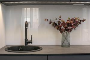 un lavandino con un vaso con fiori all'interno di Studio Deluxe Antonio a Pola (Pula)