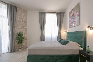 a bedroom with a green bed in front of a window at Studio Deluxe Antonio in Pula