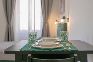 una mesa con platos y cubiertos de plata sobre un mantel verde en Studio Deluxe Antonio, en Pula