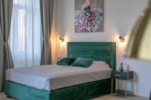a bedroom with a green bed and a painting on the wall at Studio Deluxe Antonio in Pula