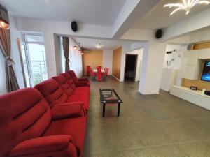 a living room with a red couch and a table at Silvester Residence in Năvodari