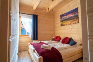 a bedroom with a bed in a log cabin at Smrekowy Domek in Kościelisko