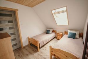 um pequeno quarto com 2 camas e uma janela em Apartament u Łowiszów em Witów