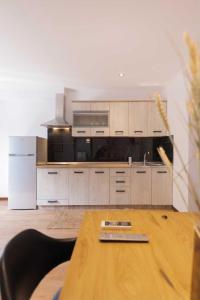uma cozinha com armários brancos e uma mesa de madeira em Kanoni Garden House em Kanoni