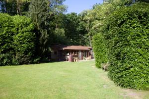 ein Gebäude in der Mitte eines Gartens mit Hecke in der Unterkunft Villa de Nachtegaal in Naarden