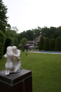 a statue of a woman hugging a child in a park at Villa de Nachtegaal in Naarden