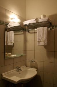 a bathroom with a sink and a mirror and towels at Hotel Platon in Athens