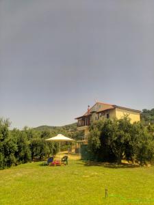 a house with an umbrella and chairs in a yard at Vrachos Sunrise Apartment in Vrachos +22 photos