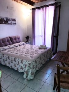 ein Schlafzimmer mit einem Bett, einem Fenster und einem Sofa in der Unterkunft Bed and Breakfast Cala Luna in Castelsardo