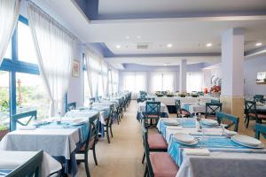 ein Esszimmer mit Tischen mit blauen und weißen Tischdecken in der Unterkunft Hotel Eliseo in Bellaria-Igea Marina