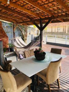 stół i krzesła na patio z hamakiem w obiekcie Cantinho da kel w mieście Bombinhas
