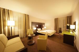 a hotel room with a bed and a couch at Hotel am See in Salzgitter +38 photos