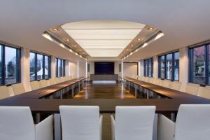 an empty conference room with a long table and white chairs at Hotel am See in Salzgitter