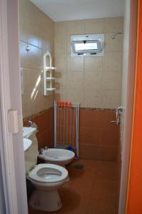 a bathroom with a toilet and a sink at Cabañas Kumelkalechi in Los Reartes