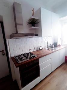 a kitchen with a stove top oven next to a sink at Skyline #Downtown in Civitavecchia