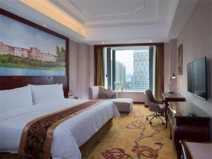 um quarto de hotel com uma cama grande e uma janela grande em Vienna International Hotel (Zhuzhou liyu store) em Zhuzhou