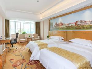 K'an-shan-chen的住宿－維也納酒店杭州蕭山機場店，酒店客房设有两张床,墙上挂有绘画作品