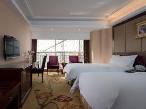 a hotel room with two beds and a television at Vienna International Hotel Changzhou Hutang in Changzhou +5 photos