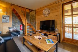 Cabaña con sala de estar con mesa y TV. en Chalet 13 personnes-Le Vanvolet en Les Saisies