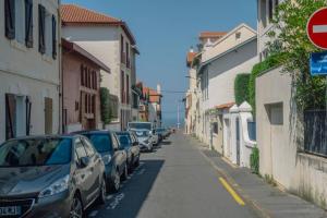 a row of cars parked on a street next to buildings at Appartement lumineux Côte des Basques in Biarritz