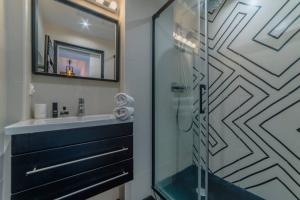 een badkamer met een glazen douche en een wastafel bij Appartement lumineux Côte des Basques in Biarritz