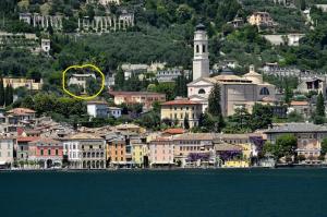 a city with a yellow circle in the middle of the water at Chicco di Senape in Gargnano