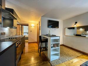 a kitchen with a counter and a table in a room at Harbourside Apartments in Portpatrick