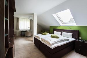 Schlafzimmer mit einem Bett und einem Dachfenster in der Unterkunft Hotel am Herkules in Kassel