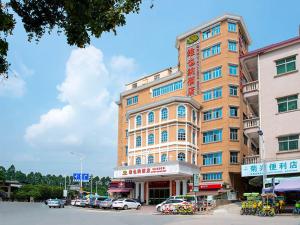een groot gebouw met auto's geparkeerd voor het bij Vienna Hotel Dongguan Songshan Lake in Dongguan