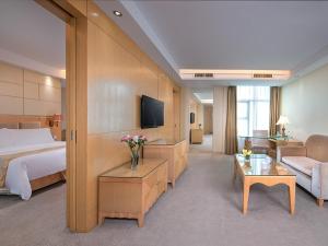 una camera d'albergo con letto e soggiorno di Vinenna International Hotel Shenzhen shajing a Bao'an