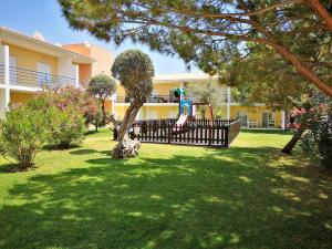 un patio con parque infantil frente a una casa en Sun & Pool Holiday Apartment, en Albufeira