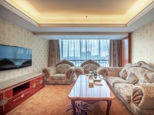 a living room with couches and a table and a tv at Vienna Hotel Foshan Chancheng Zumiao Branch in Foshan