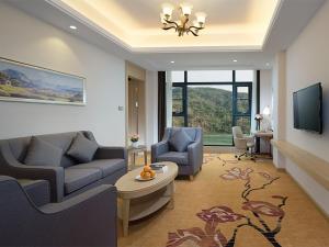 - un salon avec un canapé et une table dans l'établissement Vienna Hotels(JingHong BinJiang JunJuan), à Jinghong