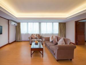 a living room with two couches and a coffee table at Vienna International Hotel Guangzhou Railway Station in Guangzhou