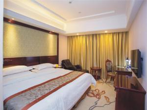 una camera d'albergo con un grande letto e una grande finestra di Vienna Classic Hotel Shanghai Hoingqiao National Exhibition Centre Xujing a Shanghai