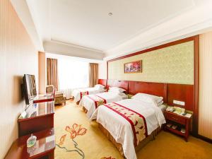 a hotel room with three beds and a television at Vienna Hotel Shanghai Jiading New City in Shanghai