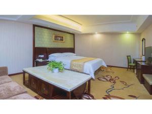 Un pat sau paturi într-o cameră la Vienna Hotel Shenzhen Fuyong Qiaotou