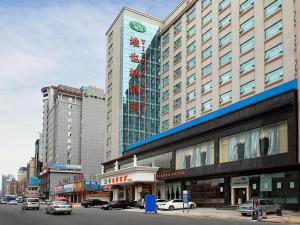 a large building with cars parked in front of it at Vienna Hotel Dongguan Changping Avenue in Dongguan